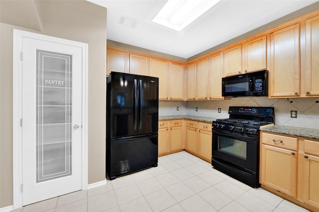 kitchen featuring light stone counters, light brown cabinets, and black appliances