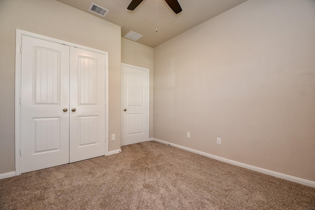 unfurnished bedroom featuring baseboards, visible vents, light colored carpet, ceiling fan, and a closet