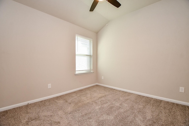 carpeted empty room featuring lofted ceiling, ceiling fan, and baseboards