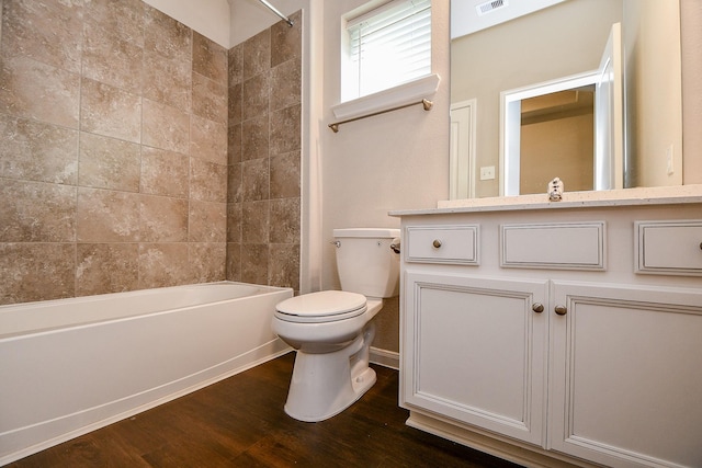 bathroom featuring visible vents, bathing tub / shower combination, toilet, wood finished floors, and vanity