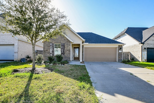 view of front of home with roof with shingles, brick siding, an attached garage, a front yard, and driveway