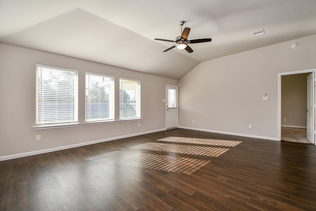 spare room with lofted ceiling, ceiling fan, dark wood-type flooring, visible vents, and baseboards