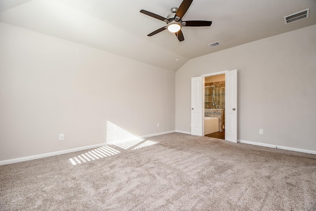 empty room with vaulted ceiling, carpet, and visible vents