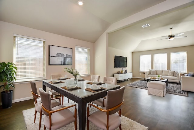 dining area featuring dark wood-type flooring, visible vents, vaulted ceiling, and baseboards