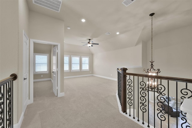 hallway featuring carpet, an inviting chandelier, an upstairs landing, and visible vents