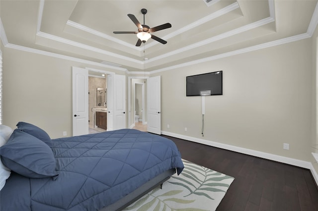 bedroom featuring ornamental molding, baseboards, a tray ceiling, and wood finished floors