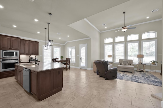 kitchen with visible vents, crown molding, light stone countertops, appliances with stainless steel finishes, and a sink