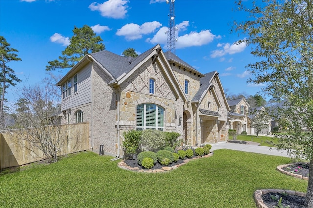 view of front of home featuring concrete driveway, a garage, stone siding, and a front yard