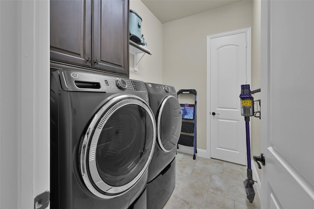 laundry room featuring light tile patterned flooring, cabinet space, baseboards, and washing machine and clothes dryer