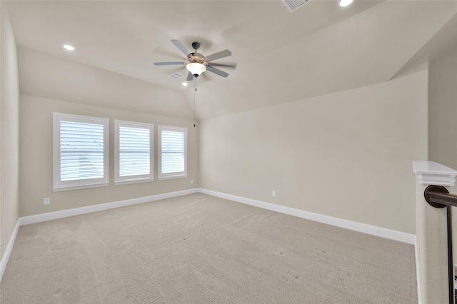 carpeted spare room with lofted ceiling, visible vents, and baseboards