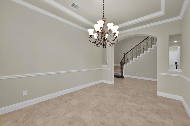 empty room with a tray ceiling, baseboards, visible vents, and crown molding