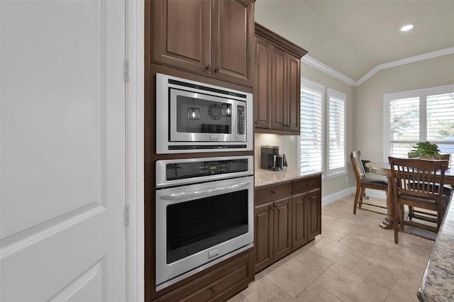 kitchen featuring light tile patterned floors, baseboards, stainless steel appliances, vaulted ceiling, and crown molding