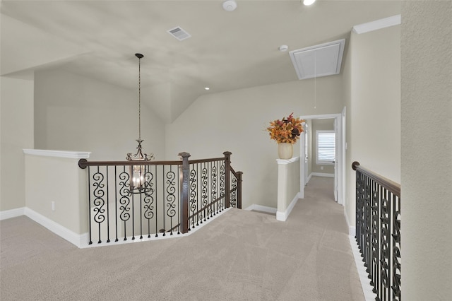 hallway with visible vents, an upstairs landing, carpet floors, attic access, and vaulted ceiling