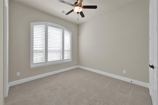 empty room with visible vents, baseboards, light colored carpet, and a ceiling fan