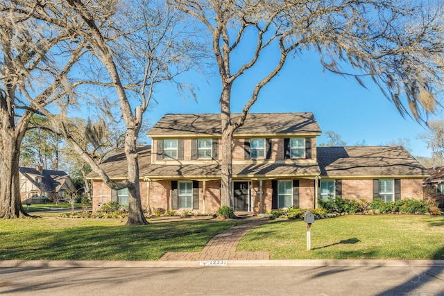 view of front of home featuring brick siding and a front lawn