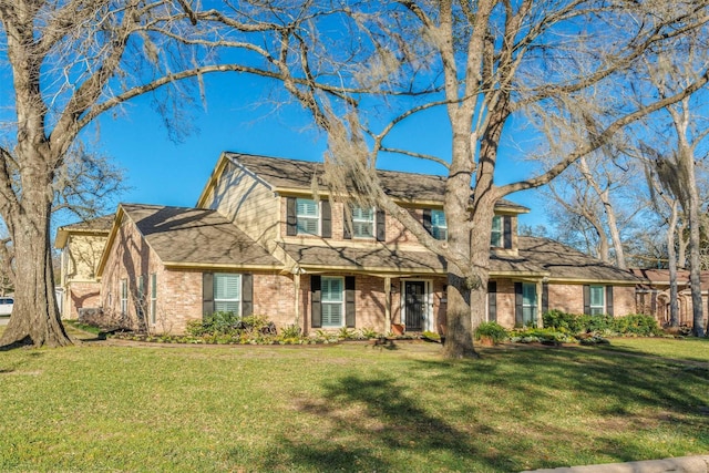 view of front of property with a front lawn and brick siding