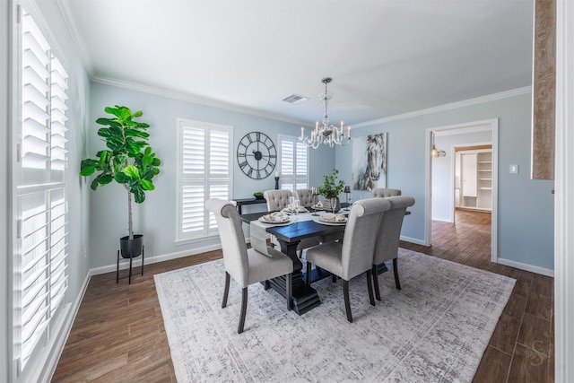 dining space with ornamental molding, dark wood finished floors, visible vents, and a notable chandelier