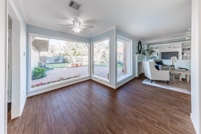 unfurnished sunroom with a wealth of natural light, visible vents, and a ceiling fan