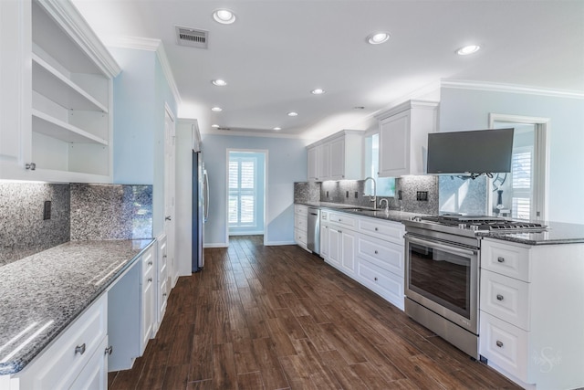 kitchen with visible vents, dark wood-type flooring, stainless steel appliances, white cabinetry, and a sink