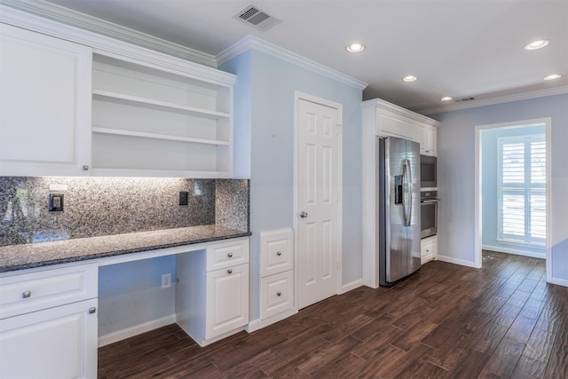 kitchen featuring dark wood-style flooring, built in desk, stainless steel appliances, visible vents, and white cabinets