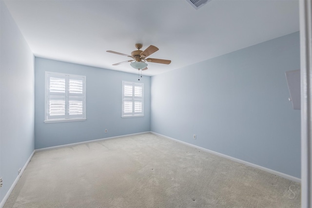 empty room with visible vents, baseboards, a ceiling fan, and light colored carpet