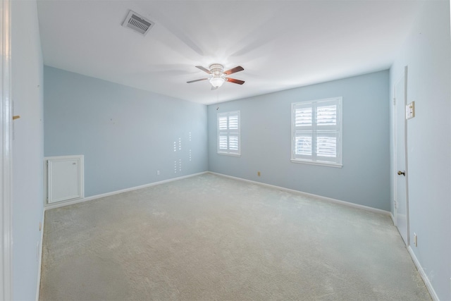 spare room with baseboards, carpet, visible vents, and a ceiling fan