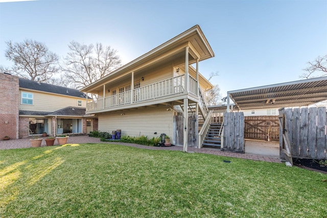 back of property with stairway, fence, and a lawn