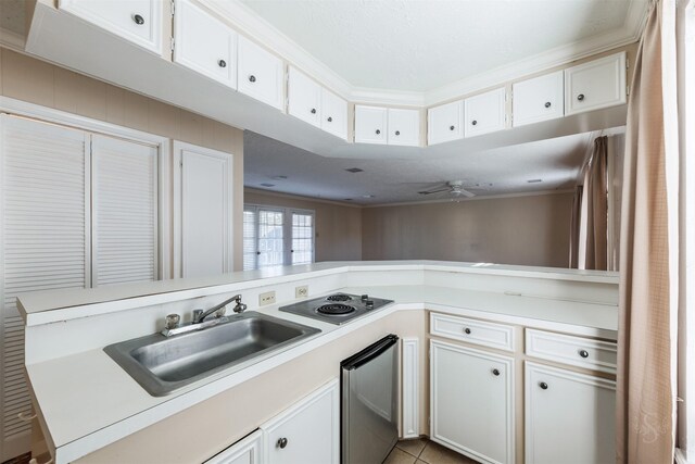 kitchen with stainless steel electric stovetop, a peninsula, a sink, white cabinetry, and light countertops