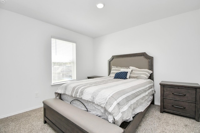 bedroom featuring light carpet and baseboards