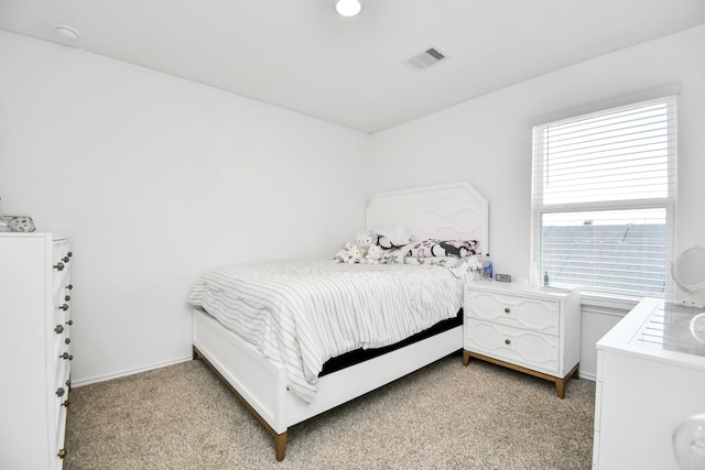 bedroom featuring light carpet, visible vents, and baseboards