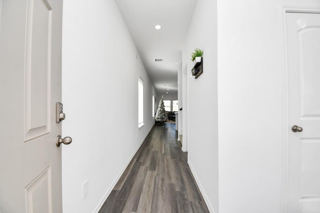 corridor featuring recessed lighting, dark wood-style flooring, and baseboards