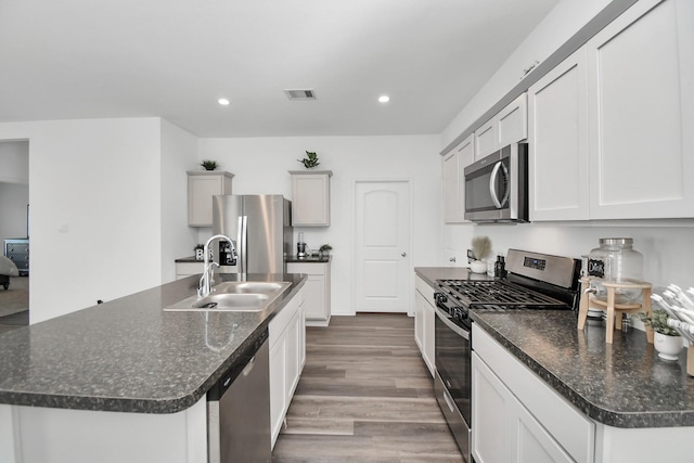 kitchen featuring visible vents, appliances with stainless steel finishes, wood finished floors, a sink, and recessed lighting