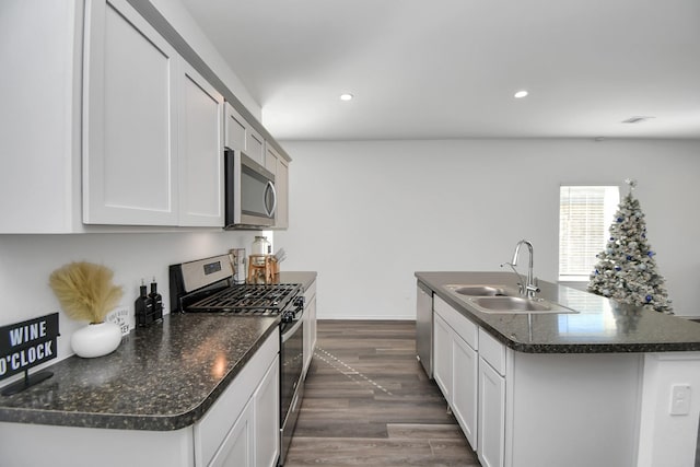 kitchen with recessed lighting, stainless steel appliances, dark wood-style flooring, a sink, and an island with sink