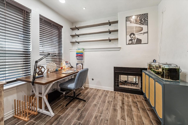 office space with recessed lighting, wood tiled floor, baseboards, and a multi sided fireplace