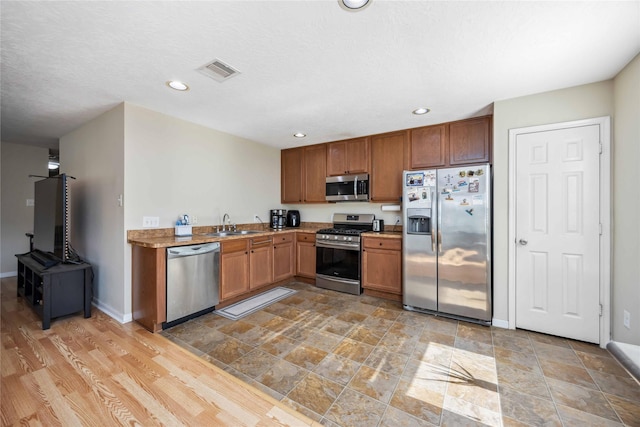 kitchen with recessed lighting, visible vents, appliances with stainless steel finishes, a sink, and baseboards