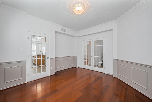 unfurnished room with french doors, visible vents, crown molding, and wood finished floors