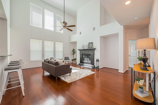 living area with recessed lighting, visible vents, a ceiling fan, dark wood-style floors, and a glass covered fireplace