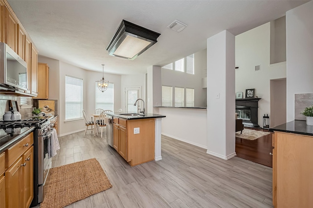 kitchen featuring appliances with stainless steel finishes, dark countertops, visible vents, and a sink