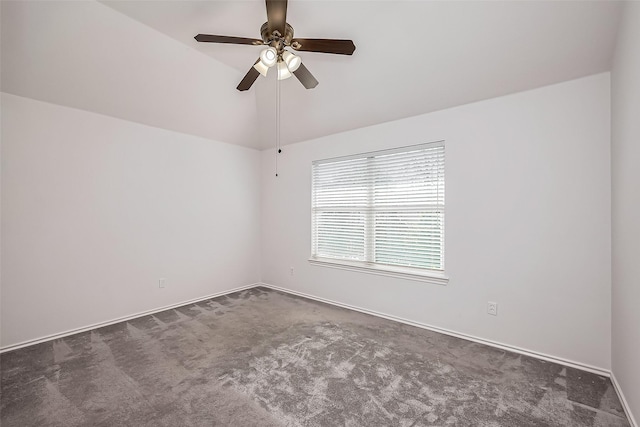 spare room featuring carpet floors, ceiling fan, baseboards, and vaulted ceiling