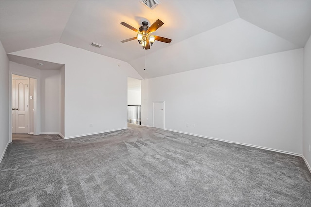 carpeted spare room featuring lofted ceiling, visible vents, and a ceiling fan