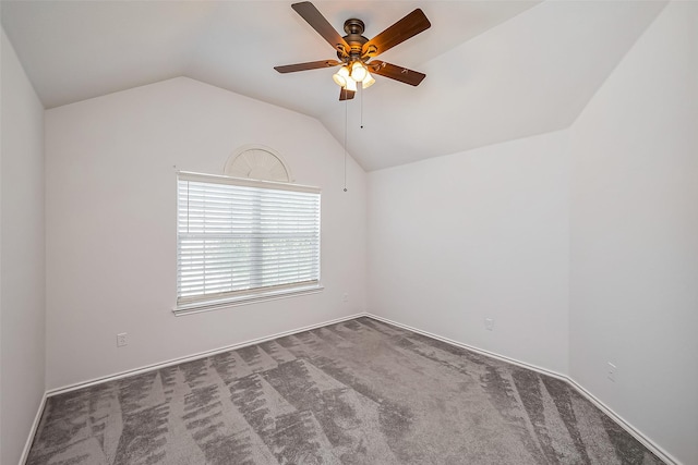 empty room featuring lofted ceiling, carpet, and a ceiling fan