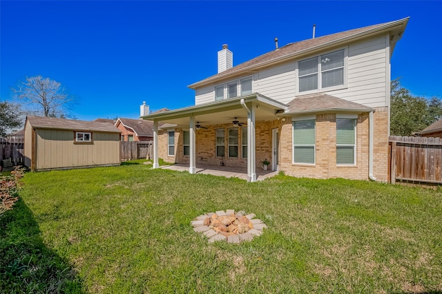 back of property featuring a ceiling fan, brick siding, an outdoor structure, and a fenced backyard