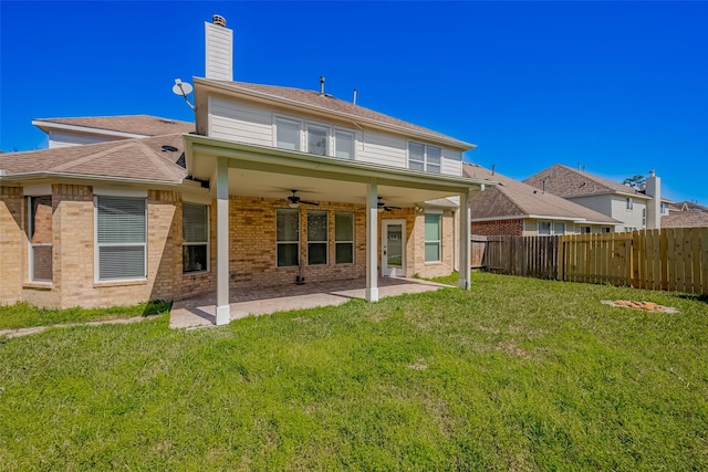 rear view of house with a fenced backyard, a lawn, a patio, and brick siding