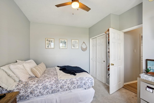 bedroom with baseboards, a closet, a ceiling fan, and light colored carpet