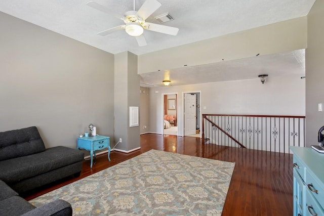 sitting room featuring visible vents, a ceiling fan, an upstairs landing, wood finished floors, and baseboards