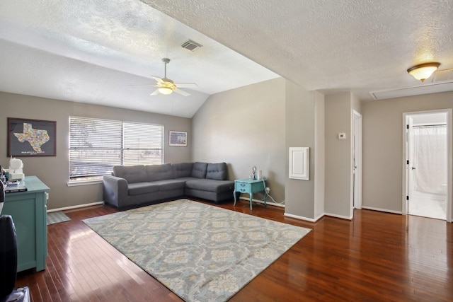 living room featuring baseboards, visible vents, ceiling fan, dark wood-style flooring, and vaulted ceiling