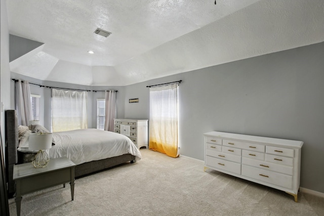 bedroom with light carpet, baseboards, and a textured ceiling