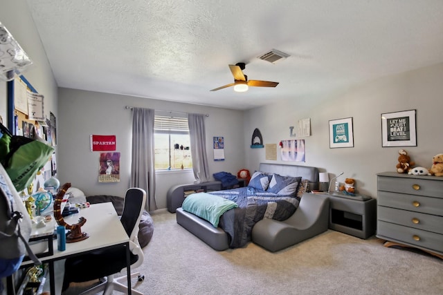 carpeted bedroom with a textured ceiling, ceiling fan, and visible vents