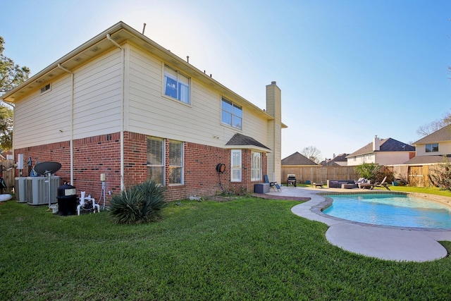 back of house featuring a fenced in pool, brick siding, a yard, a patio, and a fenced backyard