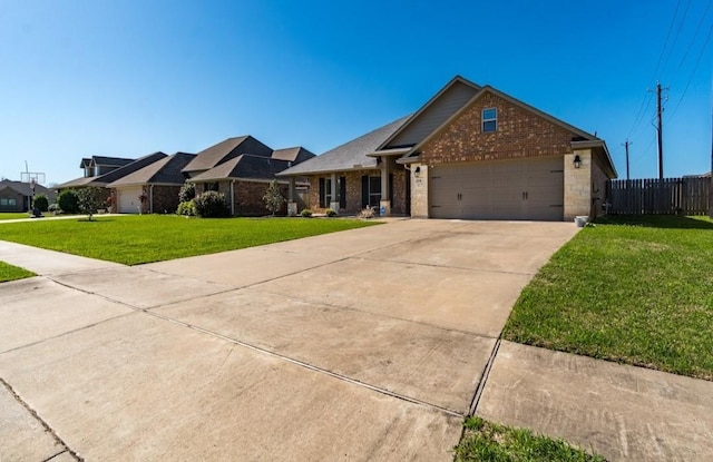 view of front of house featuring an attached garage, brick siding, fence, driveway, and a front lawn